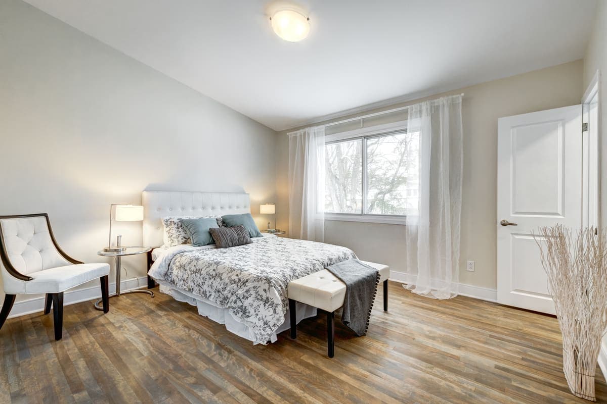 A tidy, neutral bedroom staged with simple, clean decor.